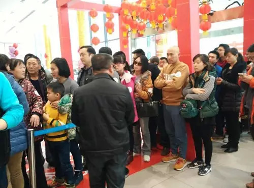 排隊(duì)領(lǐng)年貨，一家老小齊上陣。