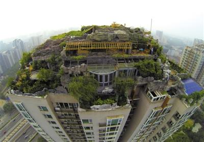 　　昨日，身穿橘黃色馬甲的工作人員在人濟(jì)山莊樓頂拆除違章建筑。新京報(bào)記者 吳江 攝