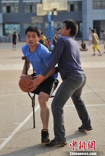 圖為拄著拐杖的瞿詩濤和同學搶球。劉占昆攝