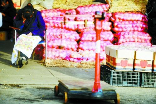 水果批發(fā)市場內，沒有客戶時，商戶在繡十字繡