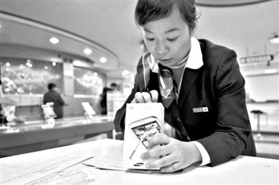 11月6日，北京移動(dòng)西直門營(yíng)業(yè)廳的工作人員在為顧客購買的4G手機(jī)登記。新華社發(fā)