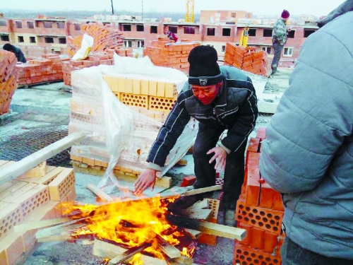 在俄羅斯工地打工時(shí)，因?yàn)樘焯?，工人不得不在工地生火取暖。（圖由方先生提供）