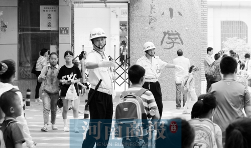 伊河路小學門口，兩名巡防隊員護送學生過馬路