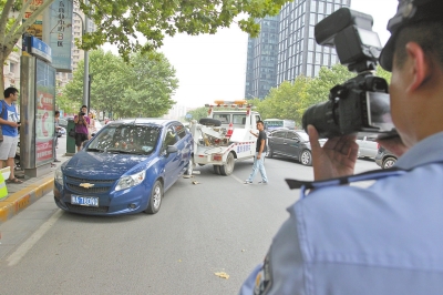 在金水路，交警對在機動車道違法停放的車輛施行拖離