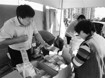 昨日，河南企業(yè)家劉春喜在京“練攤”，為顧客挑選綠豆。新京報記者 張玉學(xué) 攝