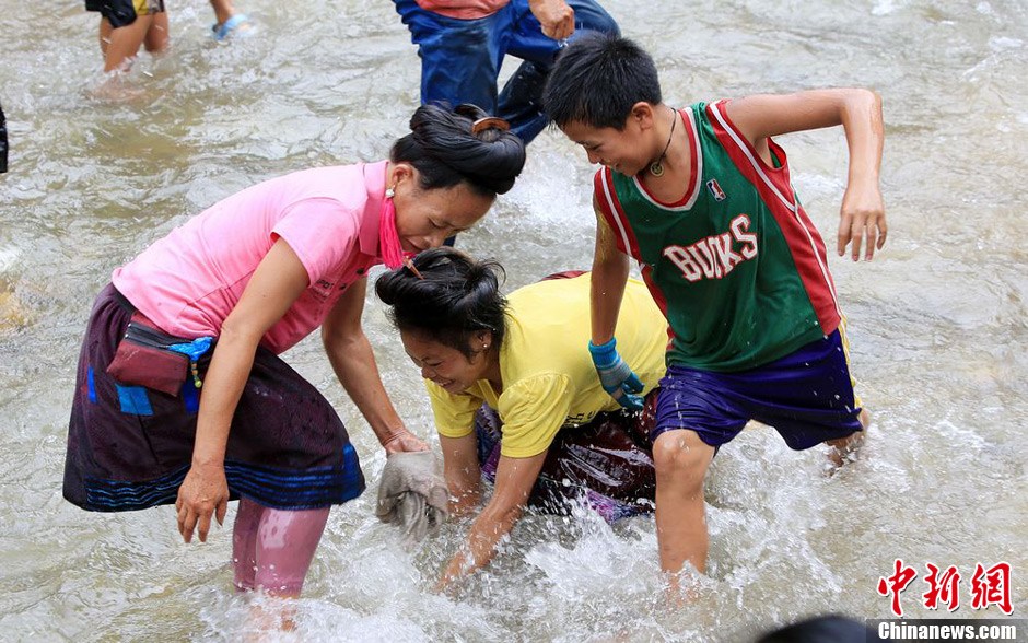 7月9日，村民在小河里摸魚(yú)搶魚(yú)。譚凱興 攝