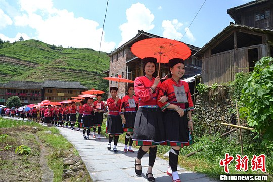 圖為新娘身著瑤族盛裝在伴娘和親友的陪伴下“出嫁”。中新社發(fā) 韋吉陽 攝