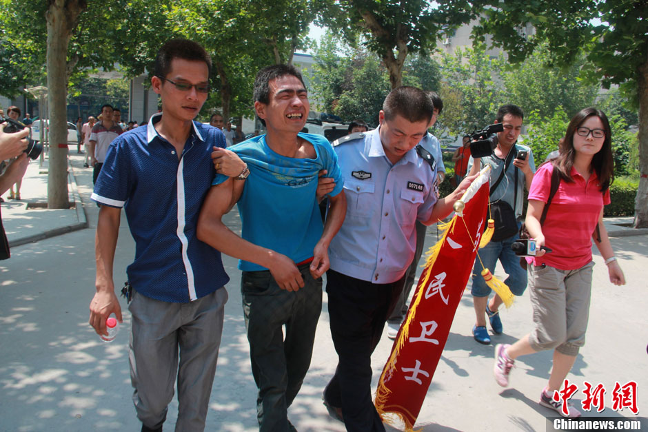 圖為獲救嬰兒父親情緒一度失控，當?shù)鼐焦ぷ魅藛T對其進行攙扶。張一辰 攝