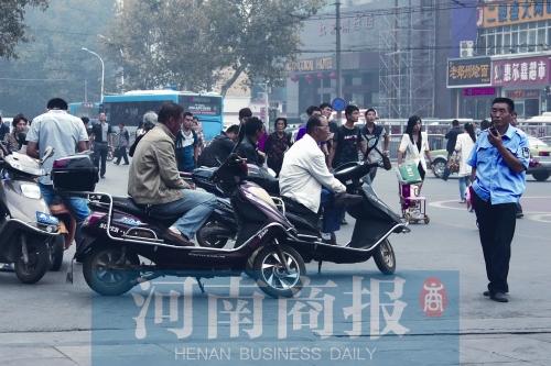 　火車站廣場(chǎng)北側(cè)，幾輛摩的正在等客