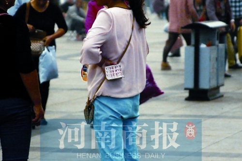 火車站廣場(chǎng)，一女子拿著寫有不同房型價(jià)位的卡片在拉客，不少市民抱怨，受過(guò)此類“騷擾”