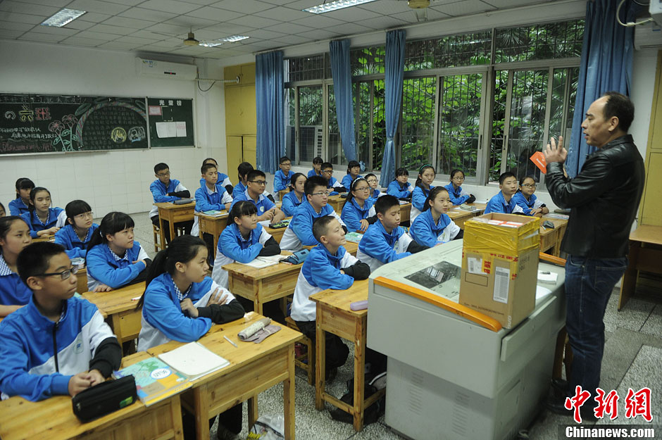 圖為老師正在向同學(xué)們講解用非智能手機(jī)對(duì)他們的好處。