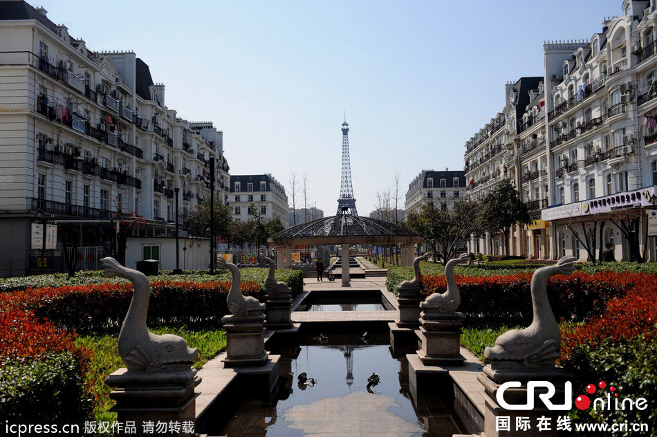 　2014年3月21日，杭州天都城，農(nóng)民在山寨埃菲爾鐵塔下耕作。圖片來源：東方IC