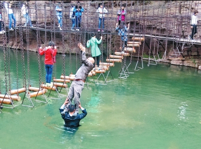 中年男游客正踩著景區(qū)安全員郭小明的肩膀過河。網(wǎng)友“@我的小名叫張孩”供圖