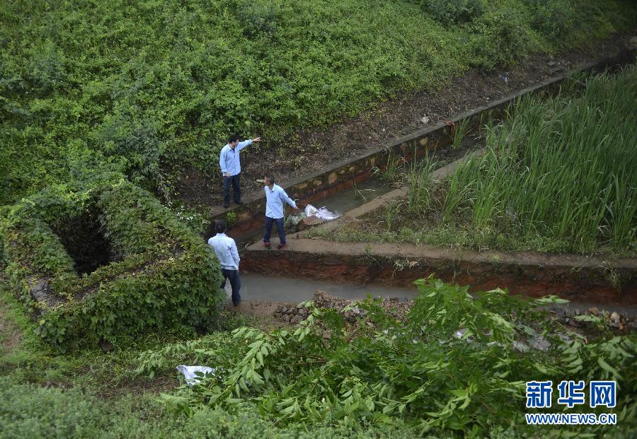 5月18日，工作人員在槽罐車泄漏現(xiàn)場(chǎng)附近的水渠邊查看情況。
