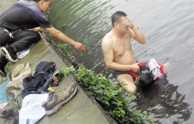 網(wǎng)友貼出民警張光聰一出河水就睜不開眼，用手抹去臉上臟水的照片。