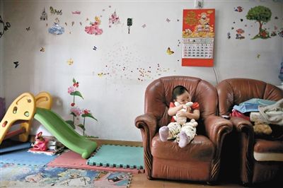 6月14日，未婚媽媽于軍的家里。女兒悅悅抱著兔子玩偶，在聽媽媽手機(jī)上的兒歌，這個(gè)4歲女孩喜歡兔子。