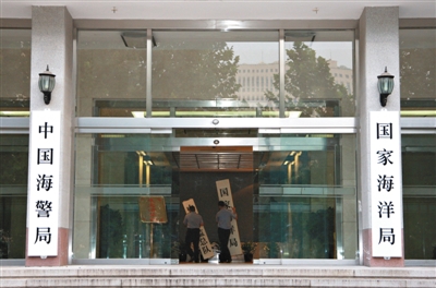 昨日，中國(guó)海警局掛牌成立。原國(guó)家海洋局和中國(guó)海監(jiān)總隊(duì)的牌匾被摘下，國(guó)家海洋局和中國(guó)海警局的新牌匾換上。黃冉 攝