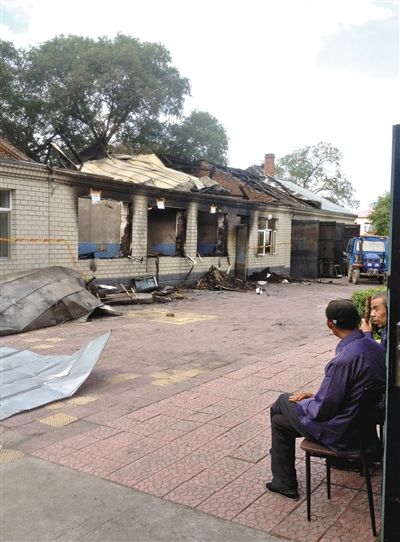 7月27日，海倫聯(lián)合敬老院內(nèi)，幾名老人看著對面被燒毀的特護(hù)病房。新京報(bào)記者 涂重航 攝