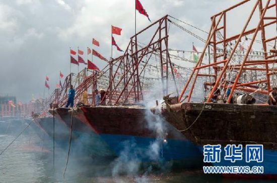 2013年8月1日 南海開漁日 臨高迎新港 8月1日，海南省臨高縣漁民在船上鳴放鞭炮慶祝武蓮港開港。