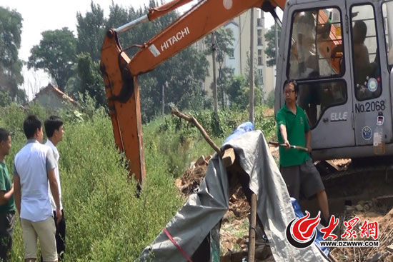 陳寶成手持自制刀斧守在挖掘機(jī)旁阻止便衣民警靠前。駕駛室內(nèi)，張朋珂正向受害人郭曉剛身上澆汽油。（視頻截圖）