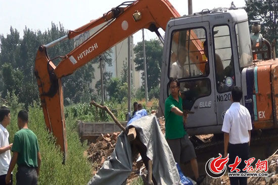 陳寶成手持自制刀斧守在挖掘機(jī)旁阻止便衣民警靠前。（視頻截圖）