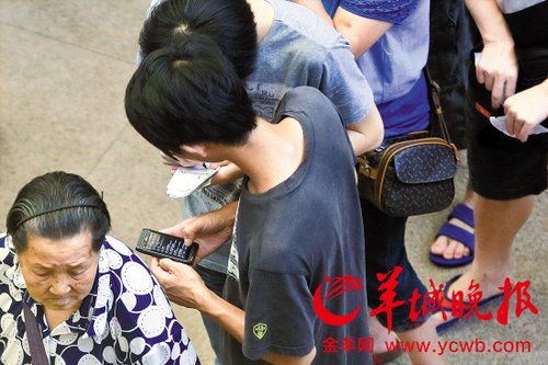 排隊的“黃?！备魇謭?zhí)一疊白紙，上面寫好了要掛號的人的信息，包括姓名、電話、要掛的科室等。穿黑白花紋衣服的老婆婆正在排隊掛號