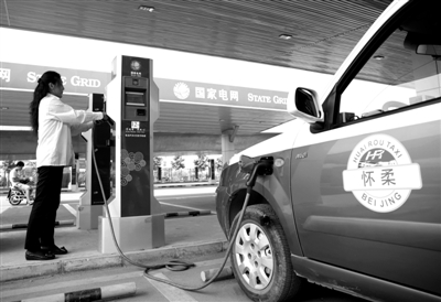 9月11日，懷柔區(qū)，電動(dòng)出租車司機(jī)正在為車輛充電。