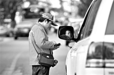 10月15日，朝陽區(qū)東大橋路，停車管理員從腰間掏出一個專用POS機(jī)，正在錄入停車信息。新京報記者 周崗峰 攝