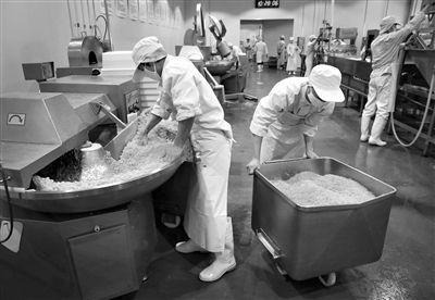 昨日，位于順義李遂開(kāi)發(fā)區(qū)的慶豐包子鋪配送中心生產(chǎn)車間，工人們正在斬拌胡蘿卜餡料。