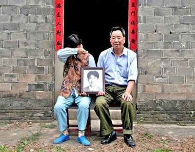 江蘇鎮(zhèn)江，老劉夫婦捧著獨(dú)生子的遺像在老家前留影南方都市報(bào)供圖L