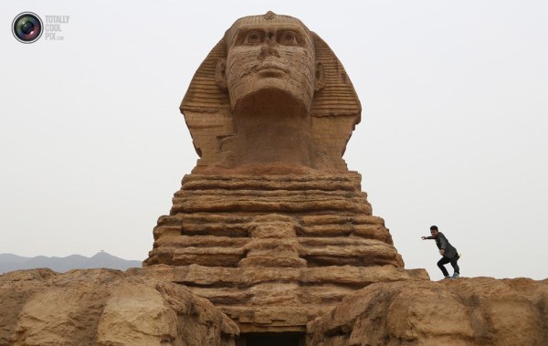 石家莊郊外，一名男子與山寨版獅身人面像合影留念。