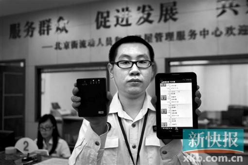 　越秀區(qū)北京街出租屋外來暫住人員管理服務(wù)中心的工作人員展示到出租屋登記來穗人員信息的儀器。