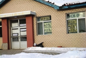 伊春市帶嶺區(qū)一排破舊的平房，房間窗戶上貼滿了“我告饒了”的字樣。