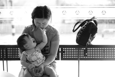 昨日，肯德基京廣中心店門口，姜女士提起跟養(yǎng)父母關(guān)系時(shí)落淚，懷中女兒笑著跟她玩。