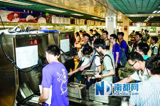 昨日，華南理工大學(xué)一食堂內(nèi)，學(xué)生們正在使用新安裝的自動(dòng)打飯機(jī)打飯。中新社發(fā)
