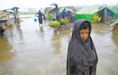 5月14日，緬甸若開邦實(shí)兌難民營，羅興亞族難民在雨中行走。熱帶風(fēng)暴“馬哈森”即將登陸緬甸，這里的難民開始乘船撤離。