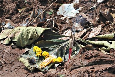 失事現(xiàn)場(chǎng),有人擺上鮮花放上香燭表示悼念。