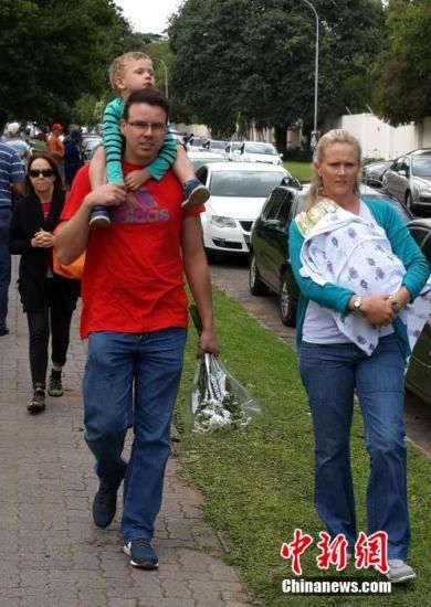 圖為一個白人家庭，由父母帶著孩子到曼德拉家門外悼念。中新社發(fā) 宋方燦 攝