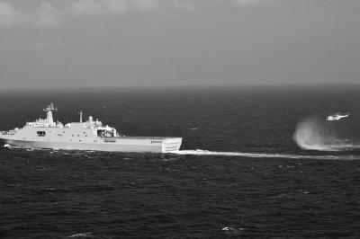 11日，抵達馬航飛機失聯(lián)海區(qū)的海軍井岡山艦與艦載直升機協(xié)同展開立體搜救行動。新華社發(fā)