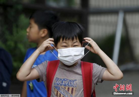 圖為當(dāng)?shù)貢r(shí)間2015年6月8日，韓國(guó)未停課的學(xué)校，學(xué)生課前戴口罩測(cè)體溫。