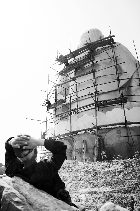 今年4月26日，工作人員將帆布蓋在“佛像”頭像上