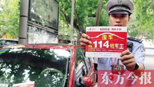 8月27日，鄭州市緯一路與經(jīng)七路交叉口，交警將“挪車請撥打114轉(zhuǎn)車主”的提示牌放在路邊?？康能嚿? width=