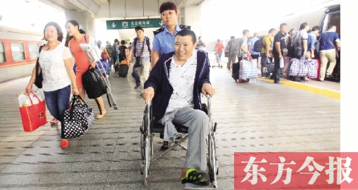 李剛手術(shù)后歸來，在車站工作人員幫助下走出鄭州火車站站臺  東方今報首席記者 張曉冬 攝
