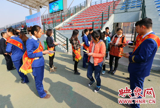 活動(dòng)現(xiàn)場(chǎng)工作人員給同學(xué)們發(fā)放宣傳冊(cè)、環(huán)保袋。