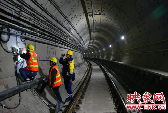 設(shè)施設(shè)備部通號室信號專業(yè)工程師正帶領(lǐng)著同事們進行軌道信號轉(zhuǎn)轍機零件更換。