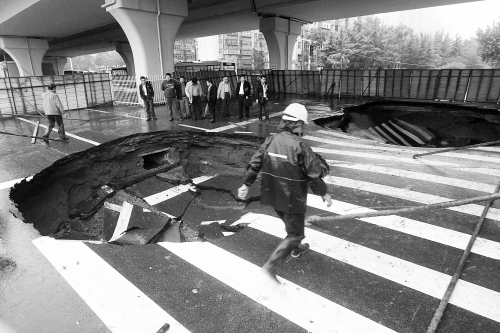 中原路西三環(huán)立交橋下由南向北原本4個車道，由于塌坑，而今3個車道被圍擋