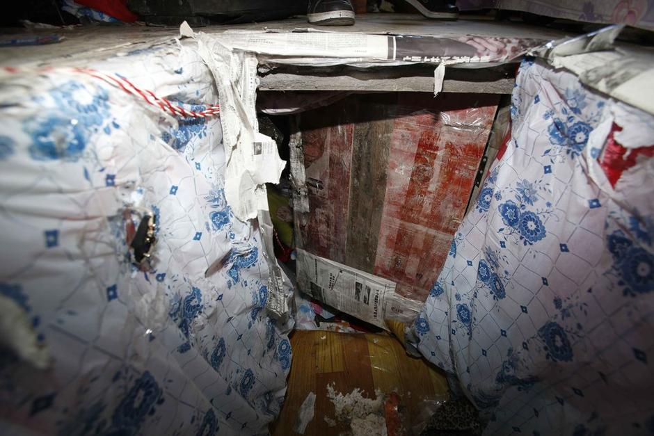 陳小龍在出租屋外，自行又圍起一堵圍墻，安裝了一個門。圍墻上都是豎起的鐵釘，外面堆著土，鄰居猜是從地底挖出來的。洞口就在床邊，0.5米見方，深約1.5米。洞口表面一塊紙板掩蓋，打開紙板跳入洞底，是一扇小木門，木門外有插銷，可以從外面鎖上。