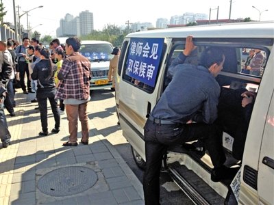 昨日，朝陽區(qū)看守所門前有人排隊。大門外還停有多輛寫有“律師會見”字樣的車。