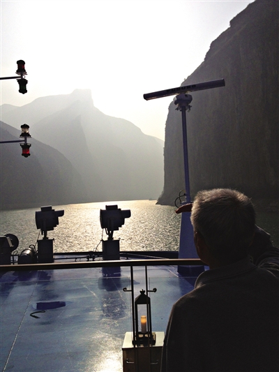 　　游客在游輪上遠(yuǎn)眺三峽風(fēng)光。