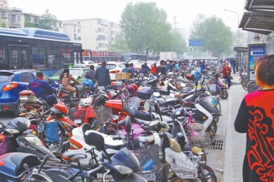 省人民醫(yī)院北門，路邊的公交站牌處停滿非機(jī)動(dòng)車，上、下客只能在快車道上。